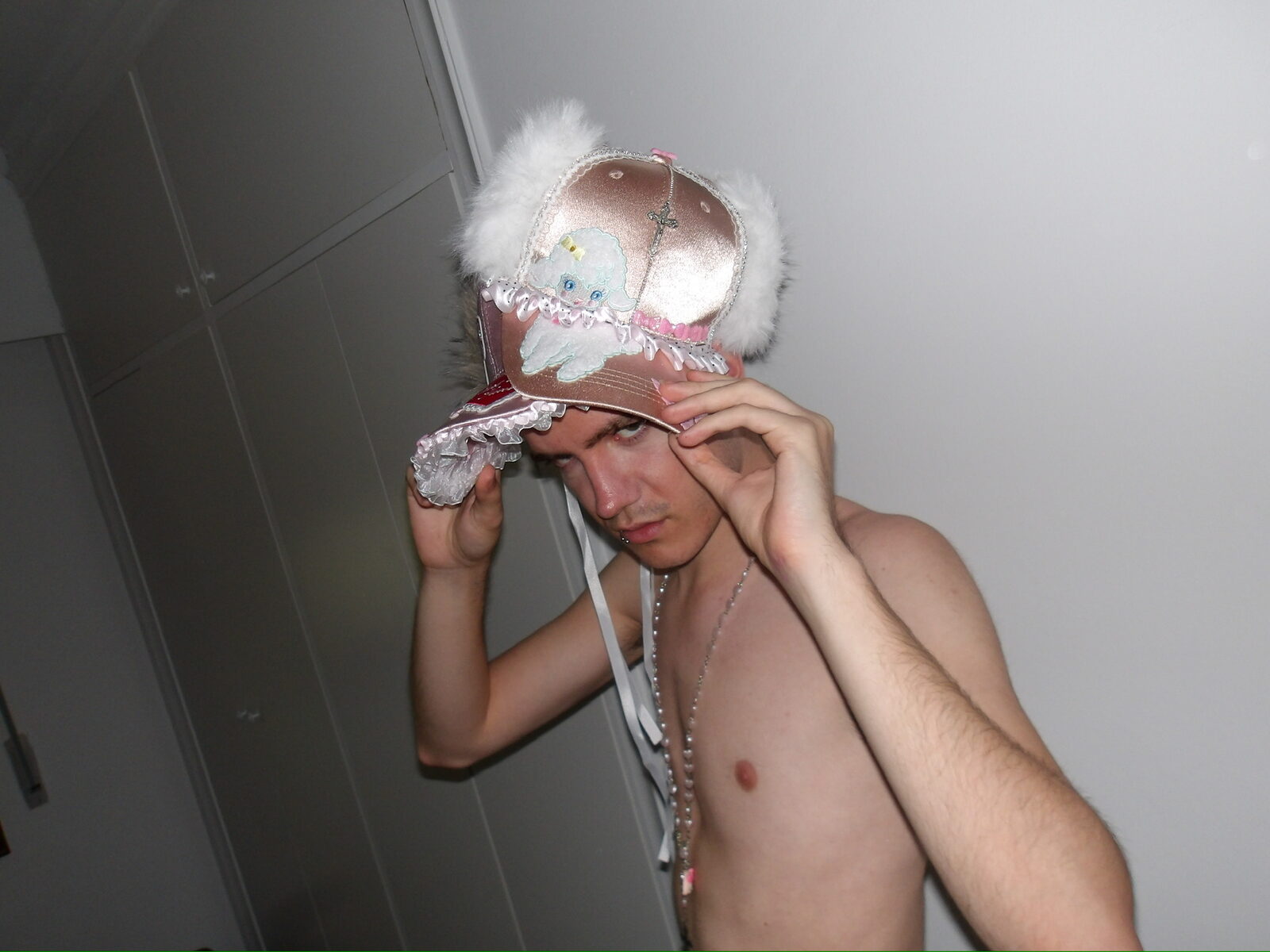 Modelo ajustándose un gorro de peluche rosa