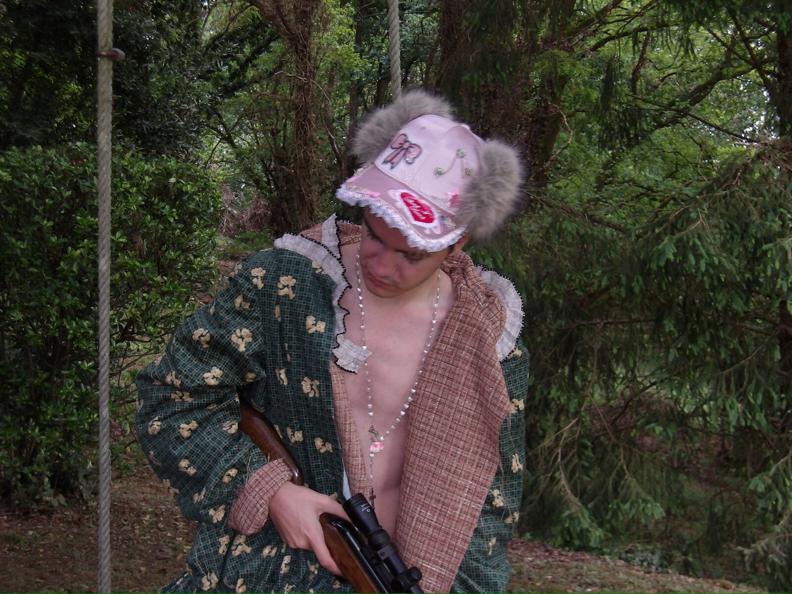 Modelo con bata de flores y gorra rosa en el bosque
