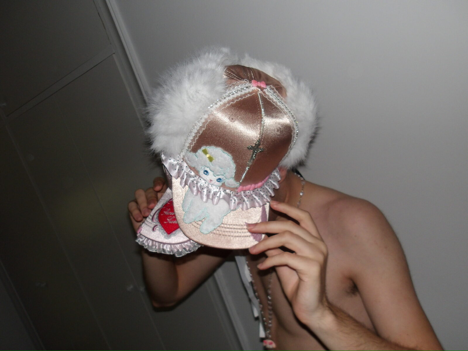 Modelo tapándose la cara con un gorro de peluche
